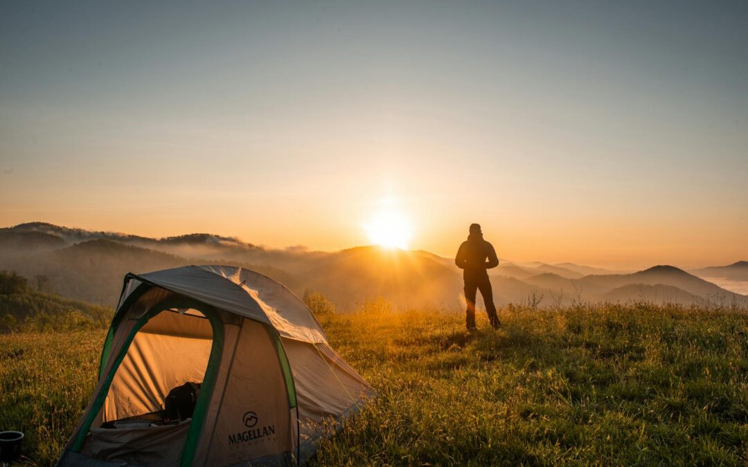 silhouette of person standing near camping tent